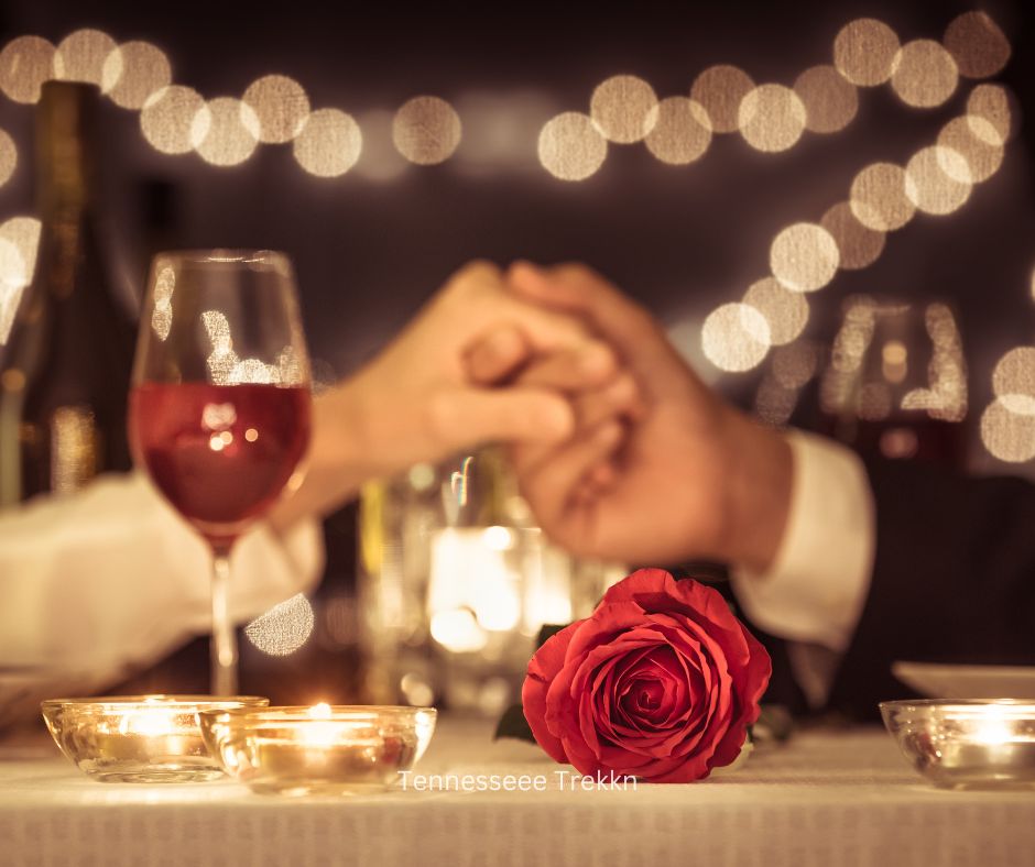 Candlelit dinner for two with a red rose and couple holding hands celebrating Valentine's Day in Gatlinburg.