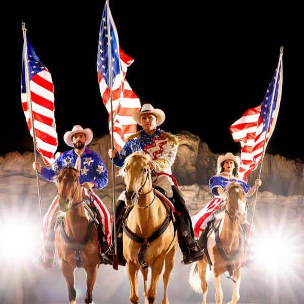 Dolly Parton's Stampede - Horses with riders carrying American flags.