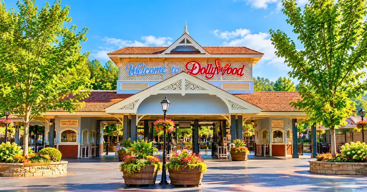 Main entrance to Dollywood theme park in Pigeon Forge, Tennessee, with colorful flower planters and welcoming signs.