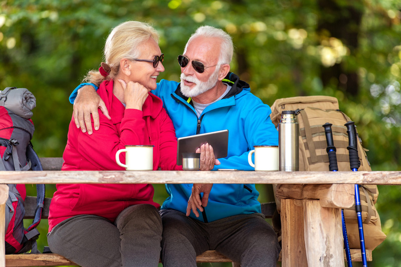 couple sitting at RV campsite picnic table enjoying themselves while having coffee while camping in  the Smoky Mountains