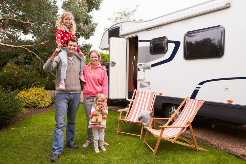 family at RV Campsite. Standing in front of white RV camper. Mom, Dad, and two daughters, Cades Cove Camping