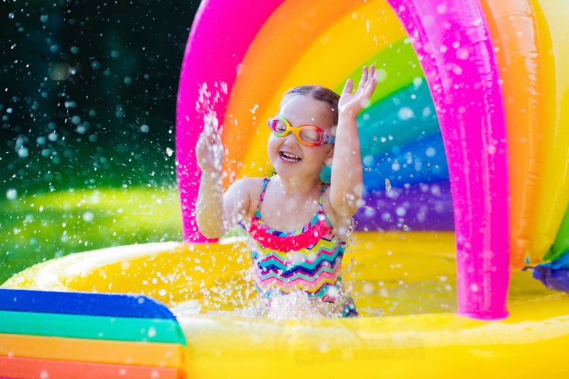 Little girl splashing water in a inflatable yellow pool. little girl enjoying camping playing in kiddie pool. Camping in the Smoky Mountains, Tennessee