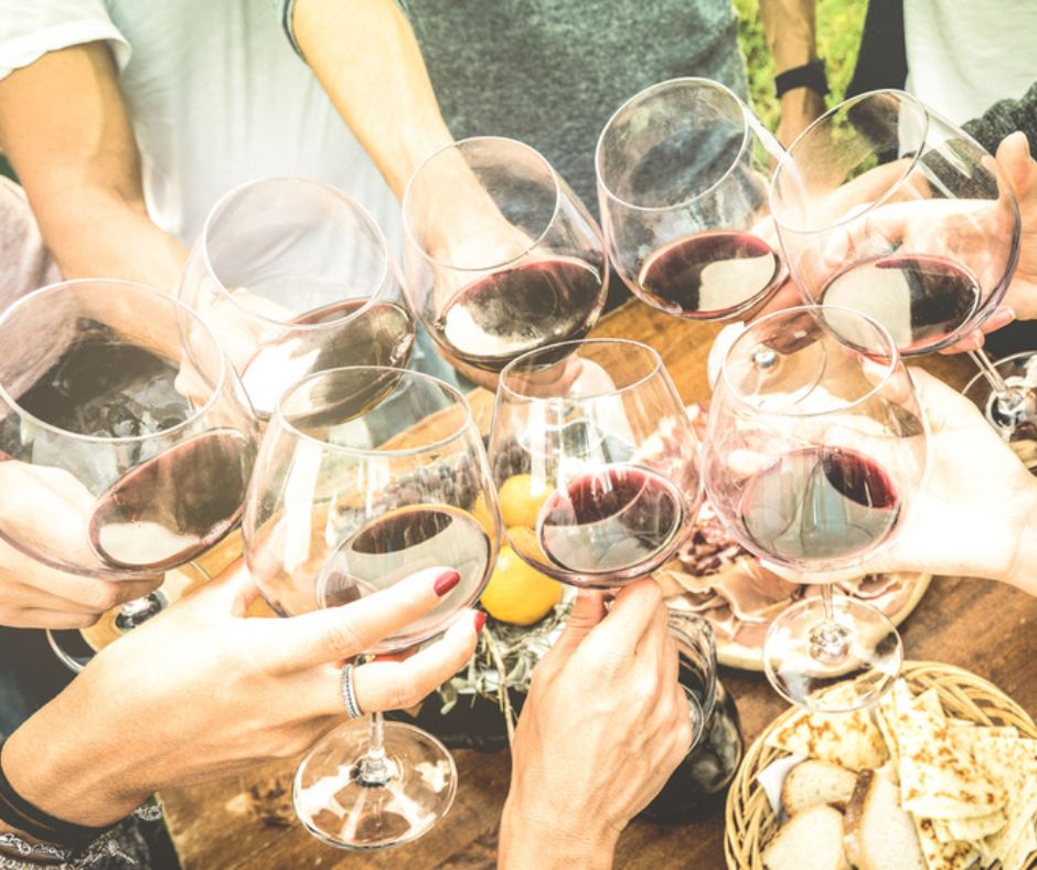 friends cheering with wine glasses; enjoy a catered lunch at their vineyards location in Bybee, TN.