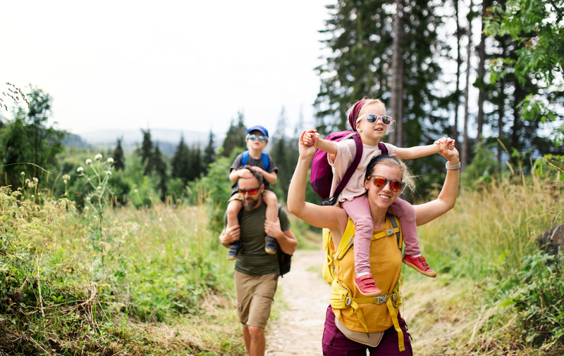 family hiking in the Smokies.  mom with her daughter on her shoulders; and dad with son on his shoulders