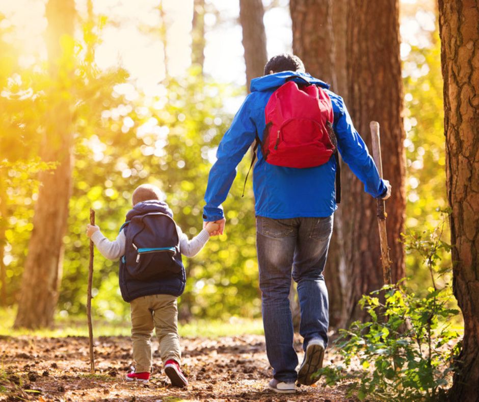 Dad and son hiking in the mountains.  Avoid getting lost on trails by being prepared with uploaded map.