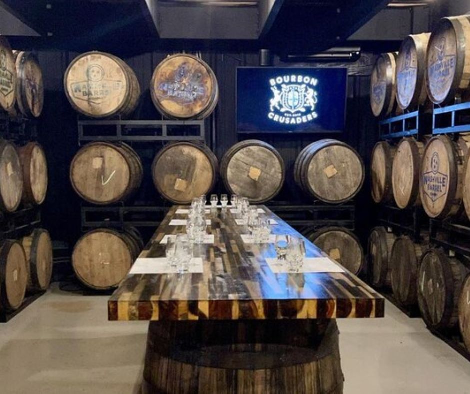 room of whiskey barrels and a tasting table