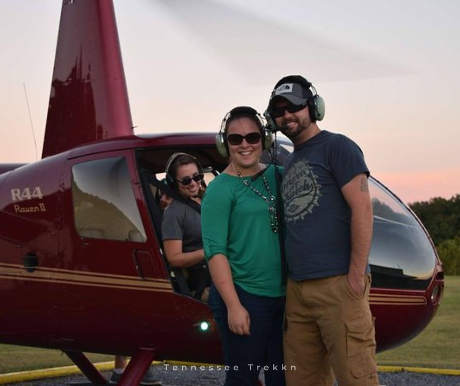 After an amazing flight, the smiles say it all. Ready for your adventure? Couple smiling after flight in front of helicopter.  