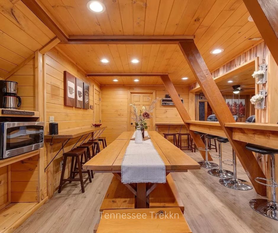 Dining area at Bear Country Lodge with long table and bar seating for large groups.