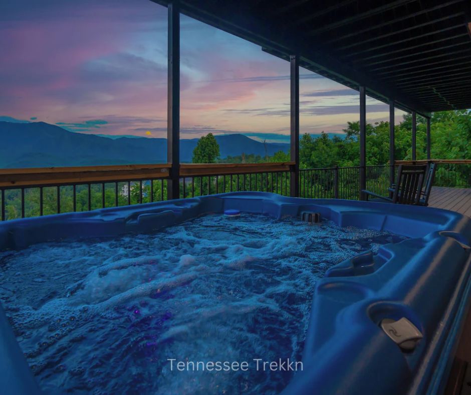 Outdoor hot tub on deck at Stayin On The Mountain with Smoky Mountain views at sunset. Chalet Village Gatlinburg Cabin