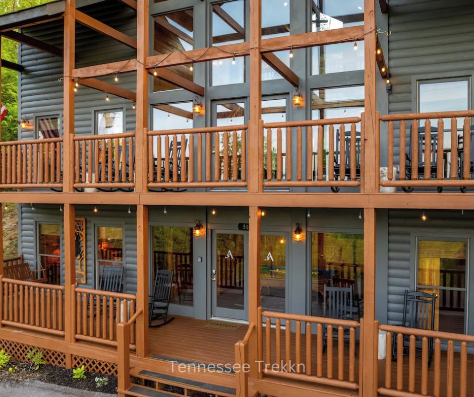 Exterior of Hollows Haven cabin with decks, rocking chairs, and large windows. Chalet Village Gatlinburg Luxury Cabin.