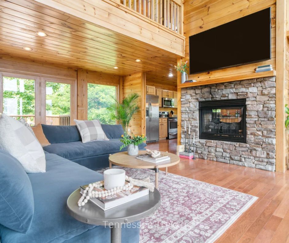 Living room area with cozy fireplace and seating at Hollows Haven cabin.