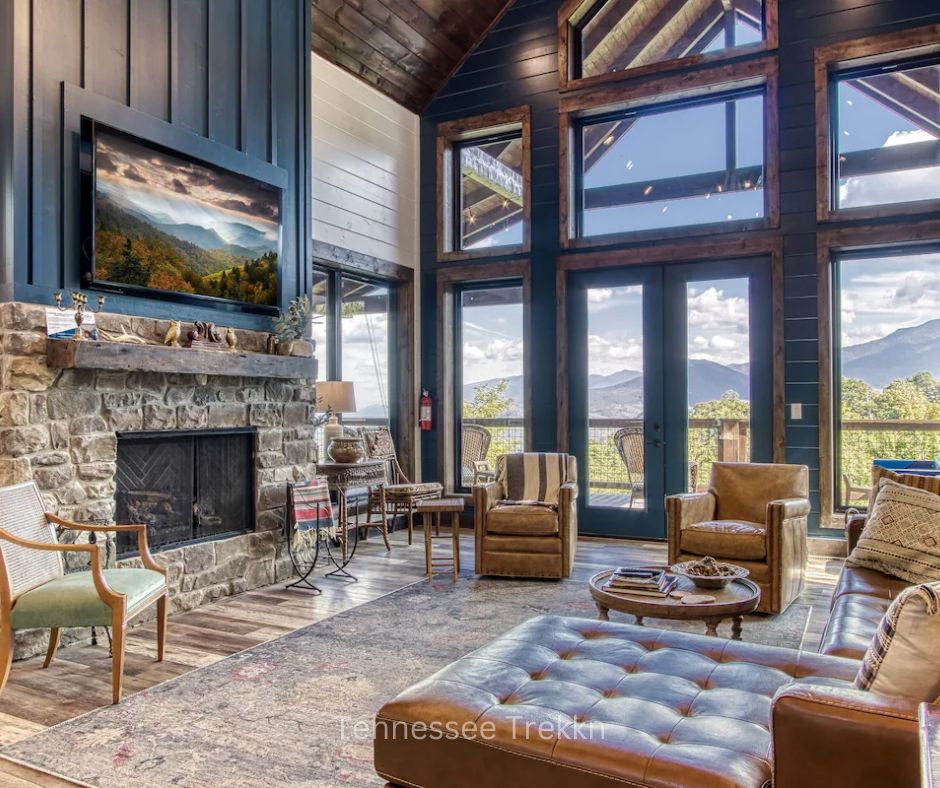 Living room at Yonder Mountain Lodge with floor-to-ceiling windows, mountain views, and fireplace."