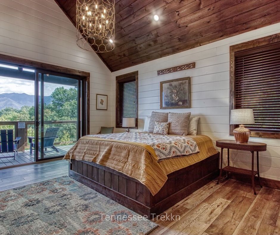 "Bedroom at Yonder Mountain Lodge with doors opening to deck and mountain views. Chalet Village Gatlinburg