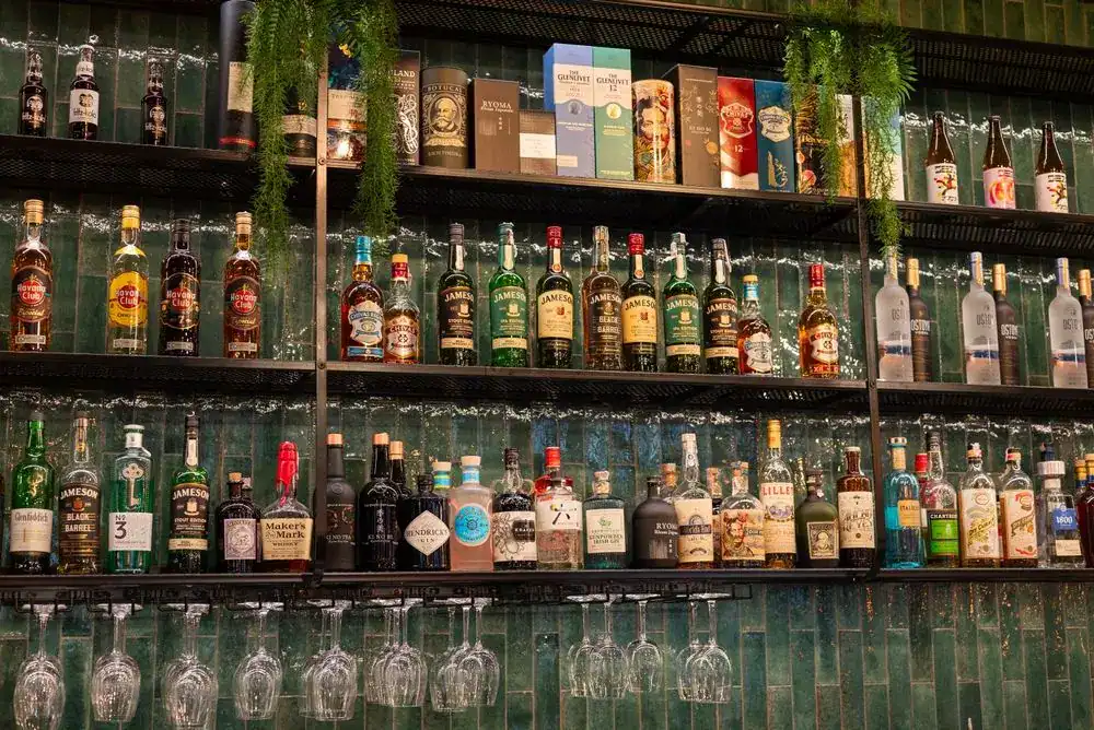 Bottles of liquor on wall at area in downtown bar. 