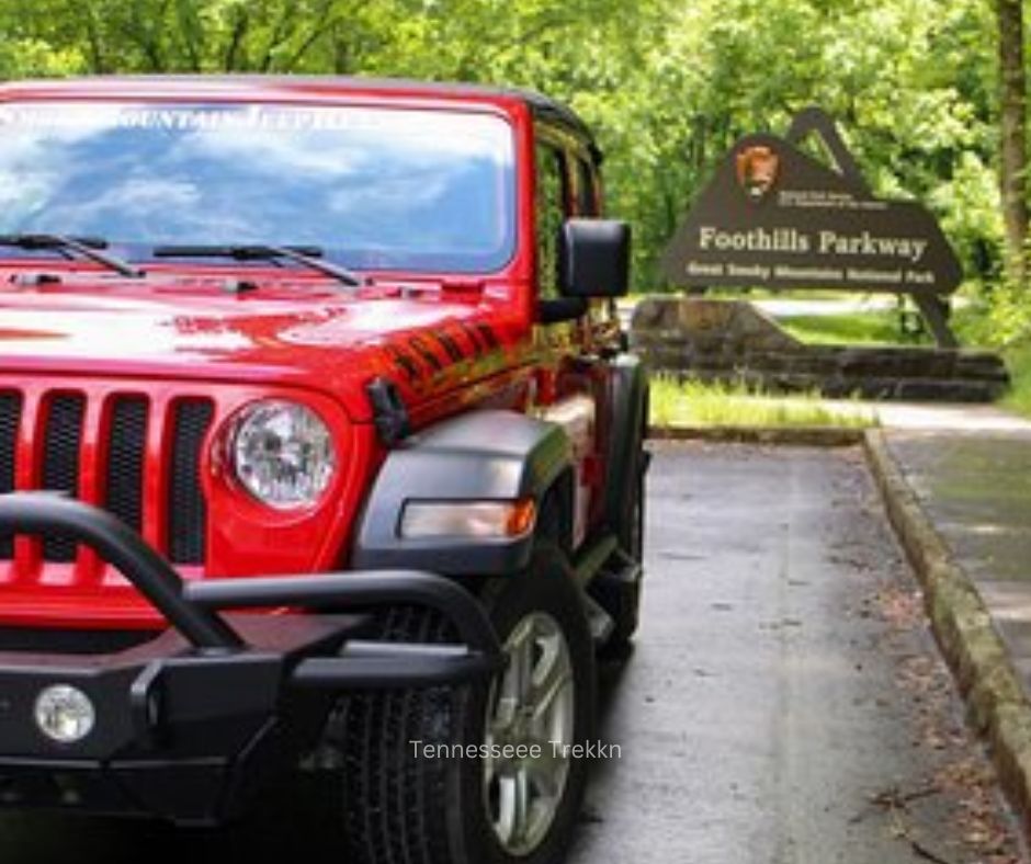 Red Jeep parked on a scenic mountain road in the Smokies, ready for an adventure