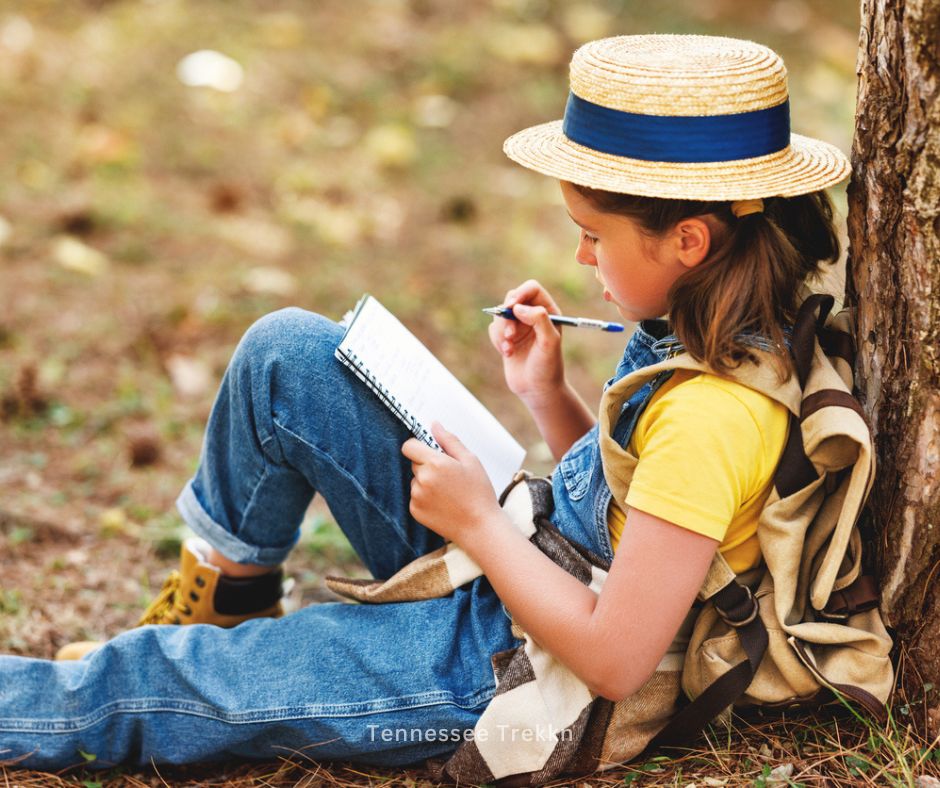 A girl sitting under a tree, nature journaling,