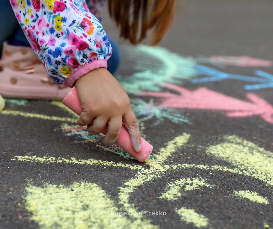 Kids drawing colorful designs on the sidewalk with chalk, 