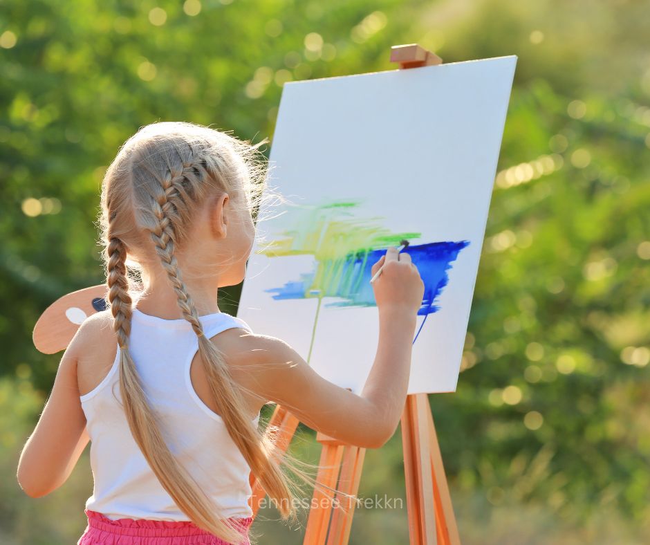 A girl painting on a kid-sized easel outside, highlighting outdoor gifts for kids that spark creativity and imagination.