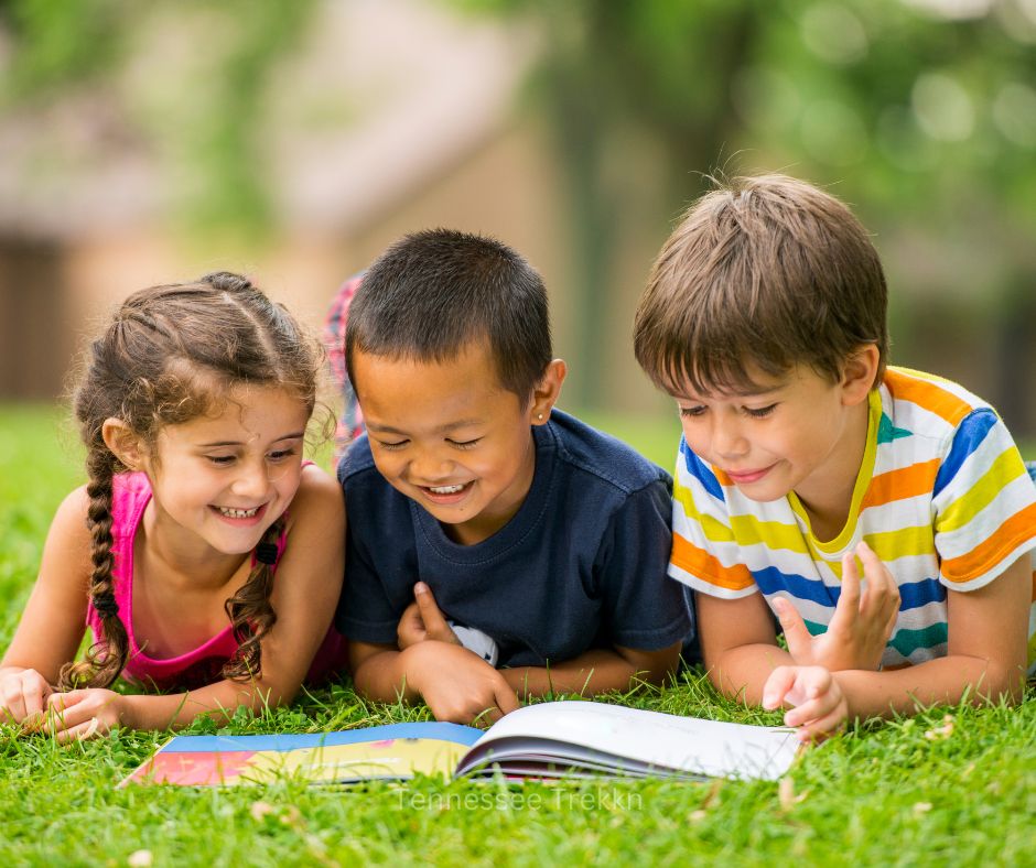 Kids sitting outside reading together, enjoying outdoor gifts for kids that inspire creativity and adventure.