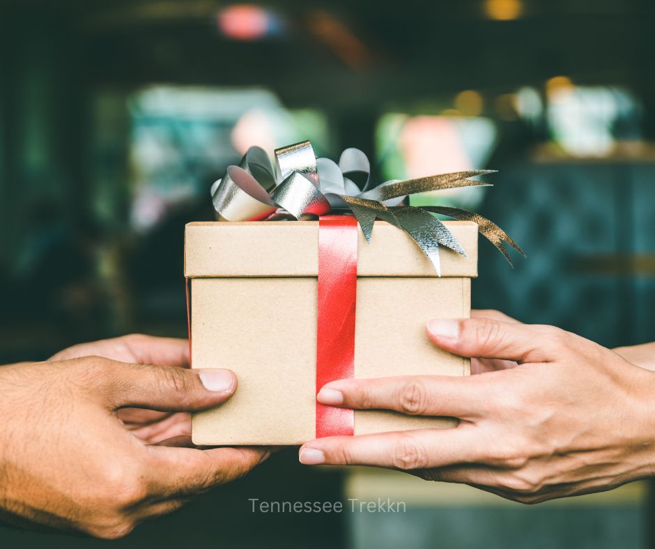 Hands passing a beautifully wrapped gift, symbolizing thoughtful gift giving from Tennessee creators.