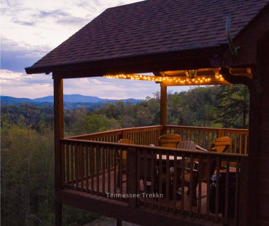 A charming outdoor porch at Moonbeams and Star Dreams, illuminated by string lights and offering a festive Smoky Mountain holiday atmosphere.