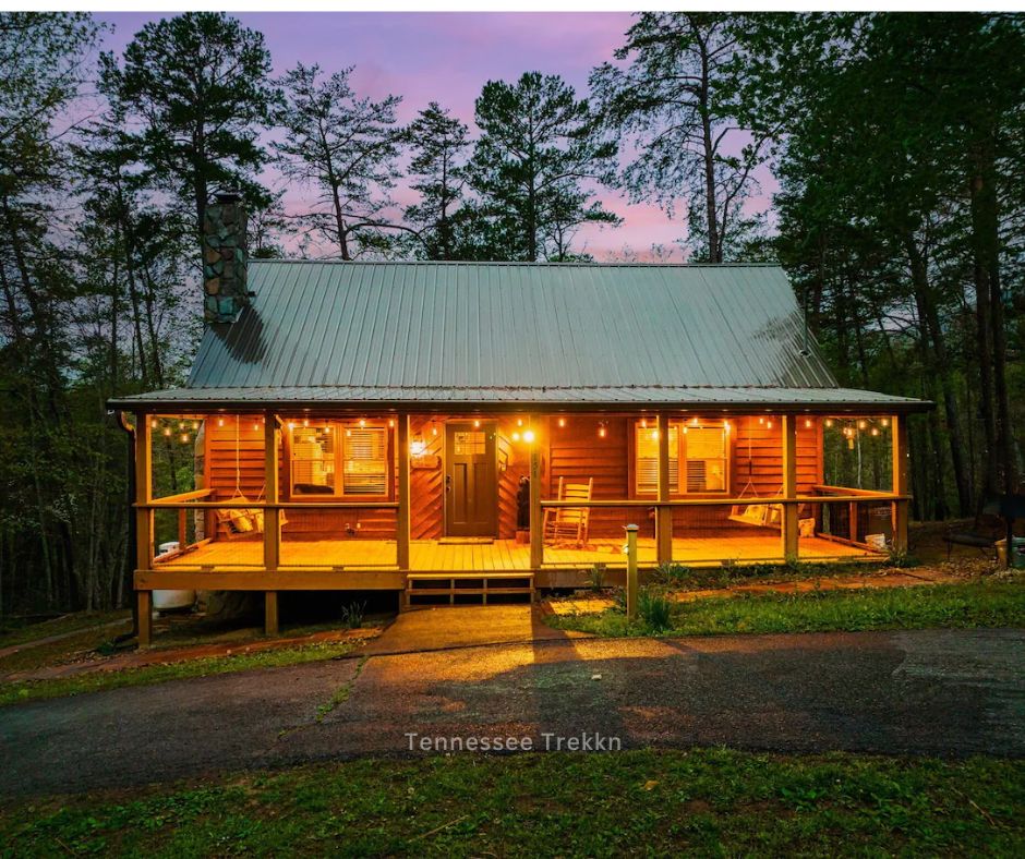 Sugar Shack cabin glowing with lights at night, a festive rental in the Smokies, surrounded by a peaceful setting.