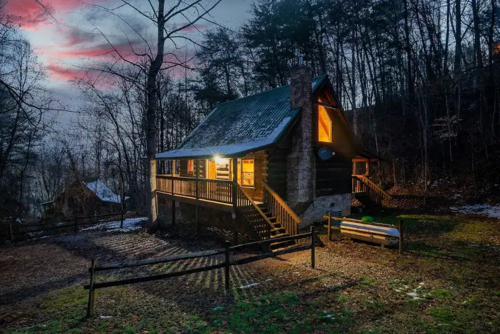 Welcoming mountain cabin lit at night. 