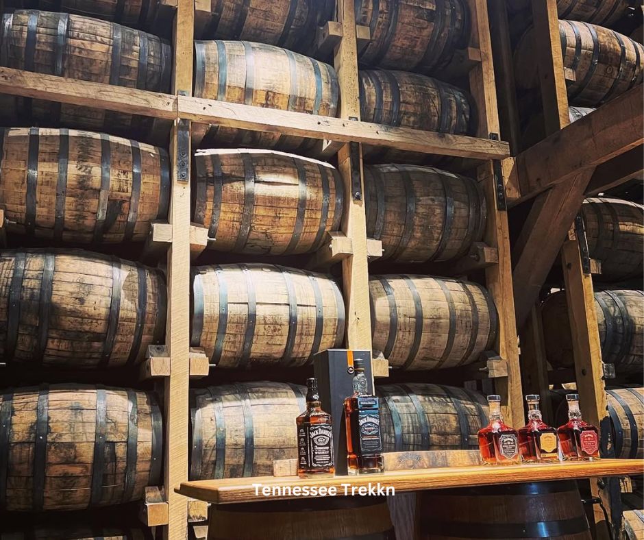 Jack Daniel’s whiskey glasses set against a backdrop of barrels in Lynchburg.