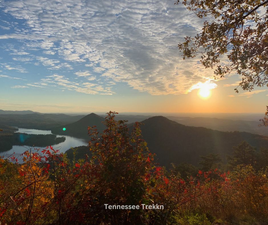 A stunning sunrise over a lake with mountain views, capturing the peaceful beauty of camping at Tennessee state parks