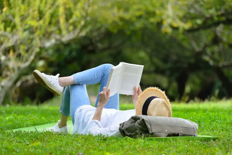 Mom reading a book in the grass—outdoor gifts for Mom that encourage rest, reflection, and fresh air moments.