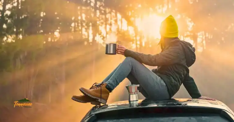 Woman sitting on top of a car at sunrise, drinking coffee and enjoying the view — perfect peaceful moment for a gift guide featuring outdoor gifts for moms and women who love nature and adventure.