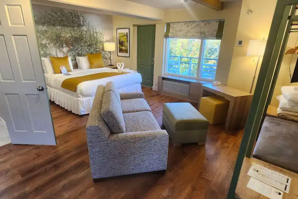 Modern suite at Arbors at Island Landing Hotel & Suites in Pigeon Forge featuring a king bed, sitting area, hardwood floors, and comfortable accommodations near The Island.