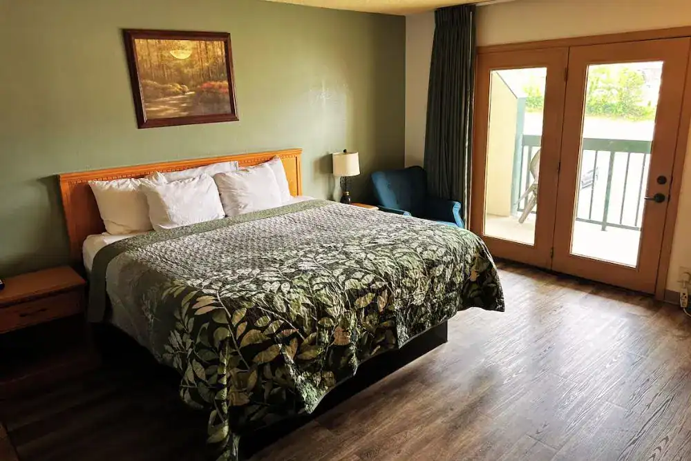Comfortable guest room with a private balcony at Grand Smokies Resort Lodge, an affordable hotel in Pigeon Forge.