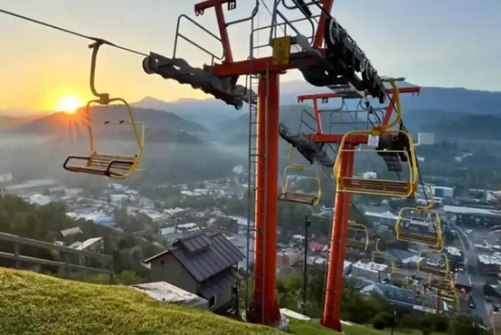 Gatlinburg SkyLift chairlifts riding up Crockett Mountain at sunrise with downtown Gatlinburg and the Smoky Mountains below