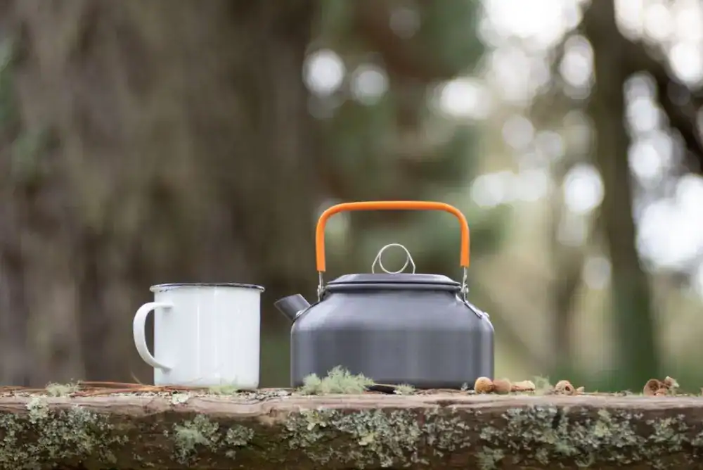 Morning coffee cup and kettle setup for brewing outdoors