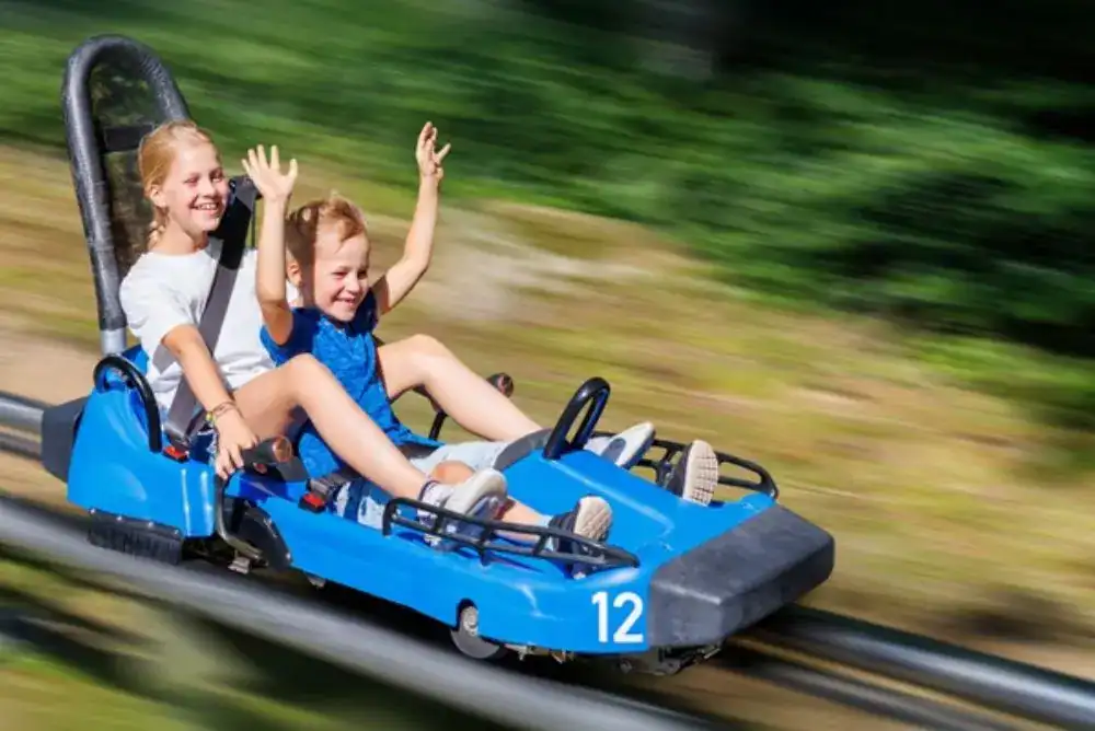 Two people riding together on one of the popular Smoky Mountain coasters during a fun getaway.