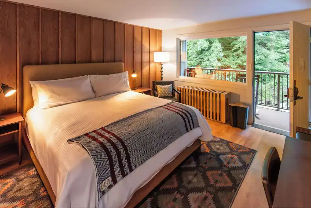 Cozy guest room at Rocky Waters Inn with a private balcony overlooking the river in Gatlinburg.