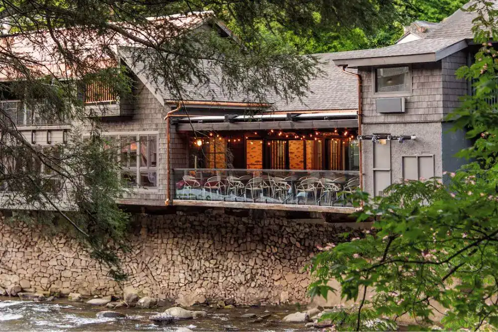 Rocky Waters Inn by the river in the evening, one of Gatlinburg’s historic hotels
