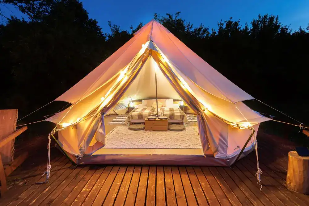 Glamping tent lit up at night. 
