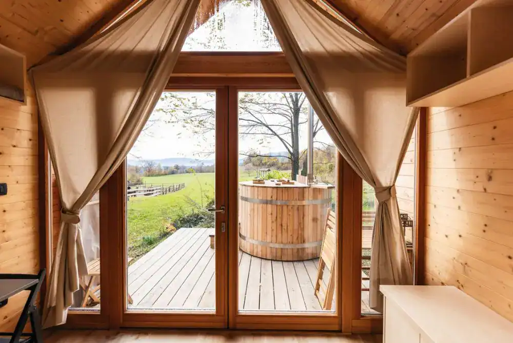 Cozy glammping cabin in the Smoky Mountains with a private deck, outdoor hot tub, and mountain views.