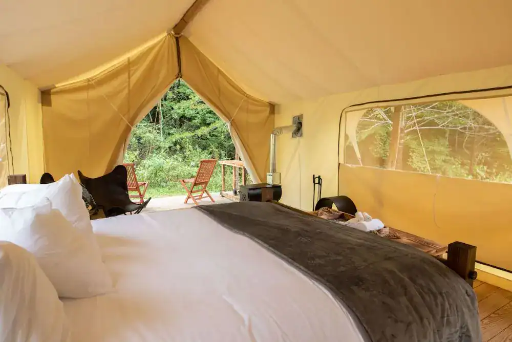 Interior view of a Suite Tent with king bed at Under Canvas Smoky Mountains