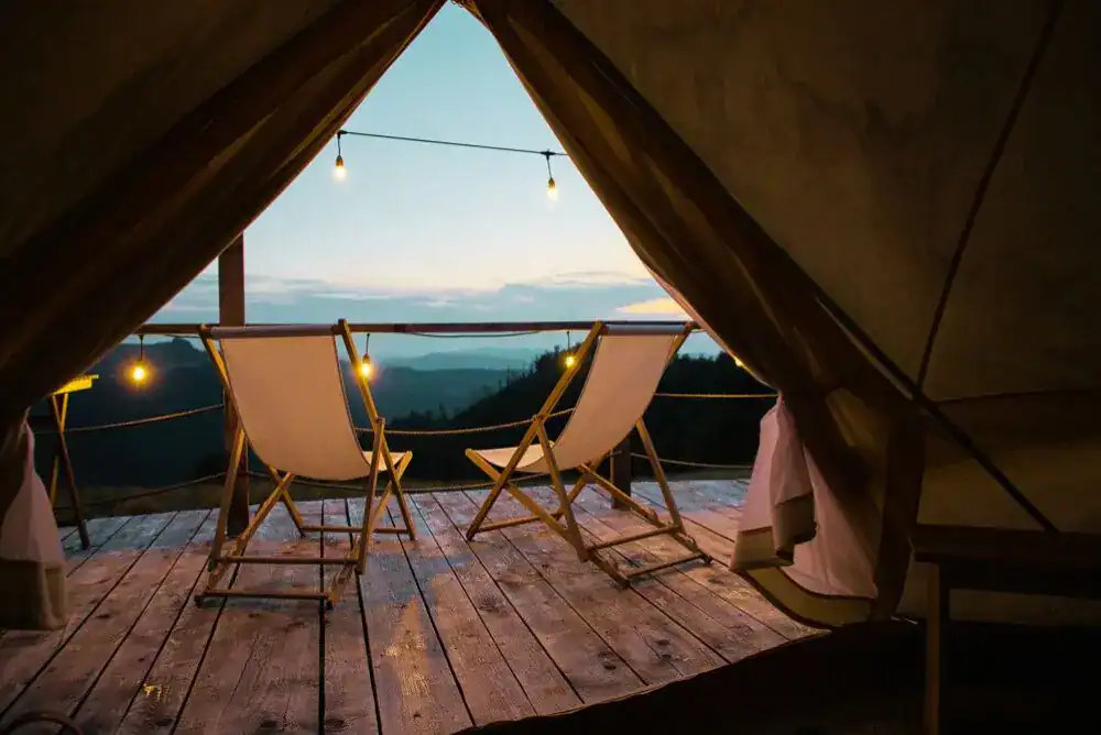 Two outdoor chairs at night overlooking the Great Smoky Mountains, capturing a quiet fall glamping moment under the stars.