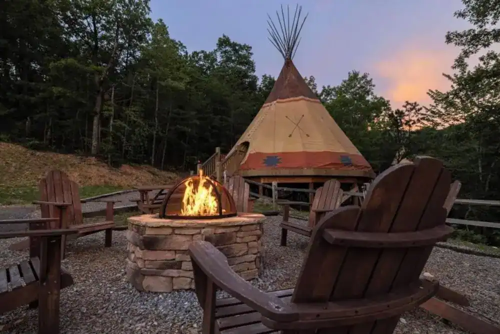 Luxury teepee glamping tent at Smoky Hollow Outdoor Resort surrounded by trees and open mountain skies in the Smokies.