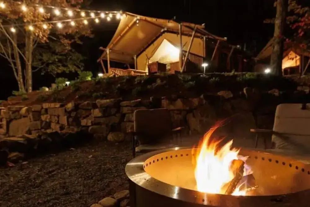 Glamping tent glowing under string lights with a crackling firepit at Rustic Bearadise near Gatlinburg
