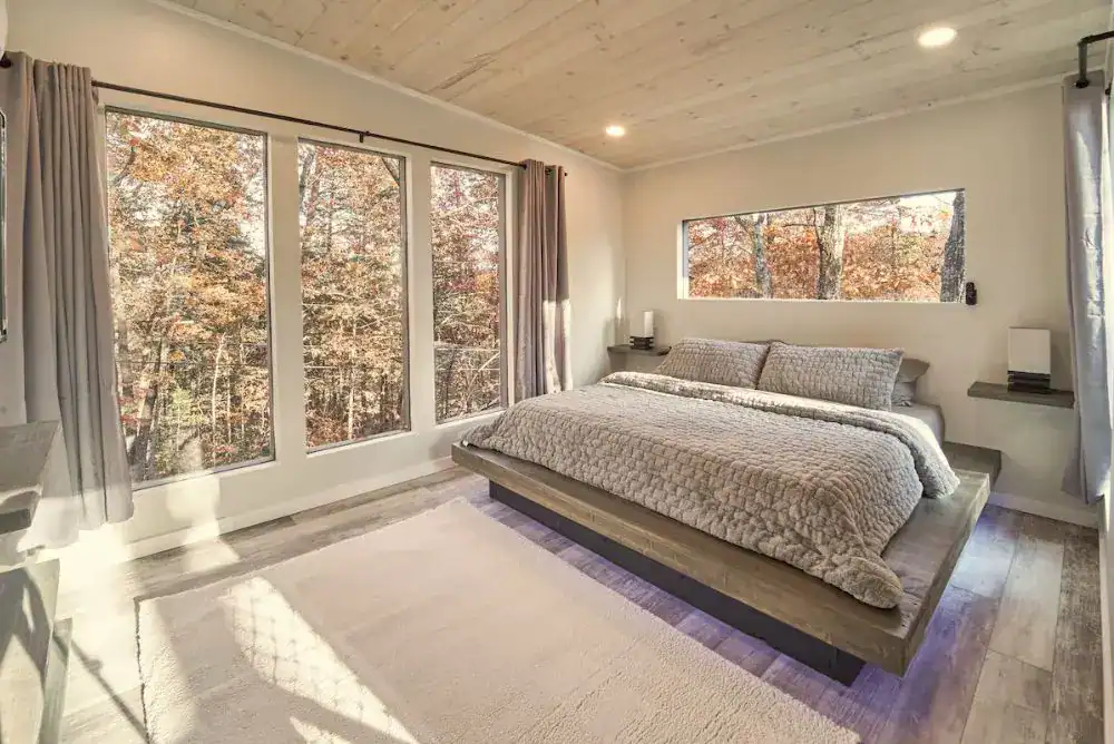 Skywalk Treehouse - Cozy bedroom inside this unique Smoky Mountain treehouse rental with king bed, modern design, and warm lighting.