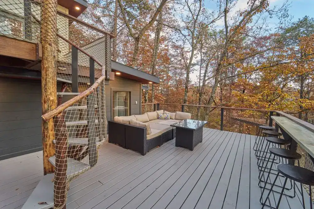 Outdoor seating area at a luxury Smoky Mountain treehouse rental with bar-style dining and forest views near fun in the Smokies.