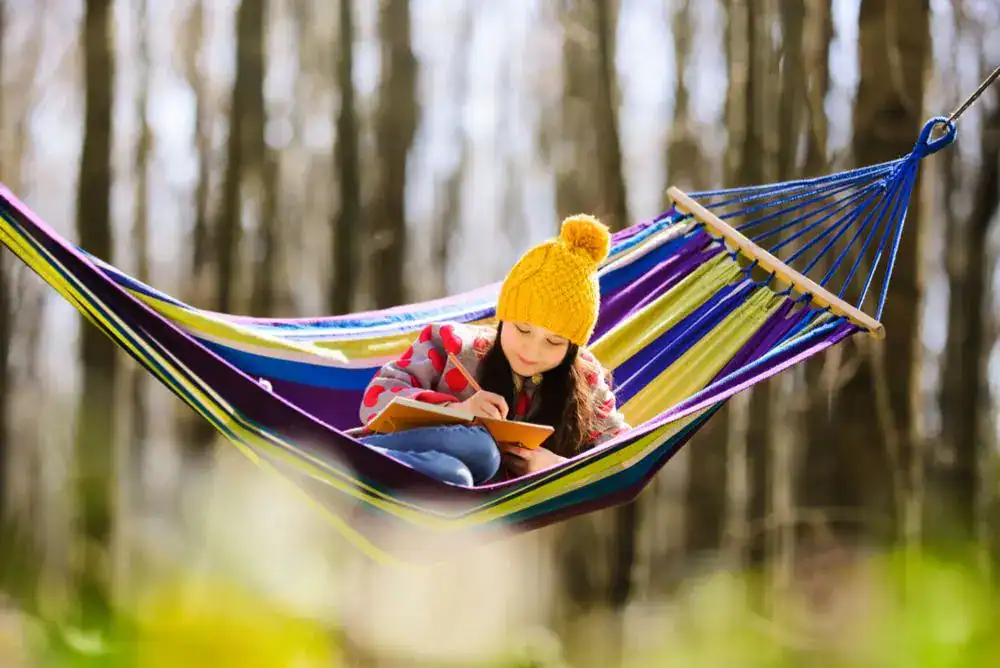 Kid relaxing in a hammock during an outdoor adventure.