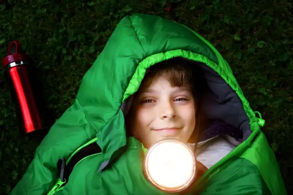 Boy in a green sleeping bag featured in our outdoor Christmas presents  guide.