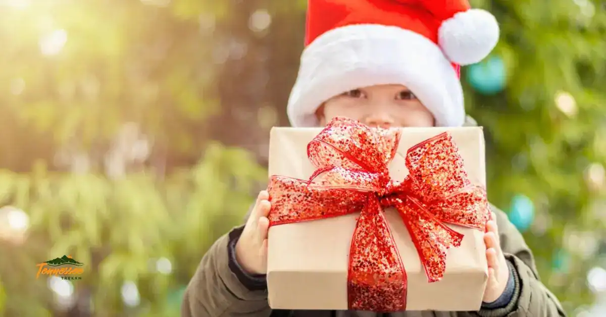 Child holding a wrapped present outside, featured in an outdoor Christmas gifts for kids guide for Tennessee Trekkn.