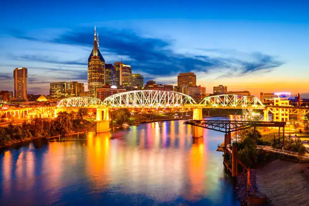 Nashville TN skyline at sunset with the Cumberland River and downtown city lights